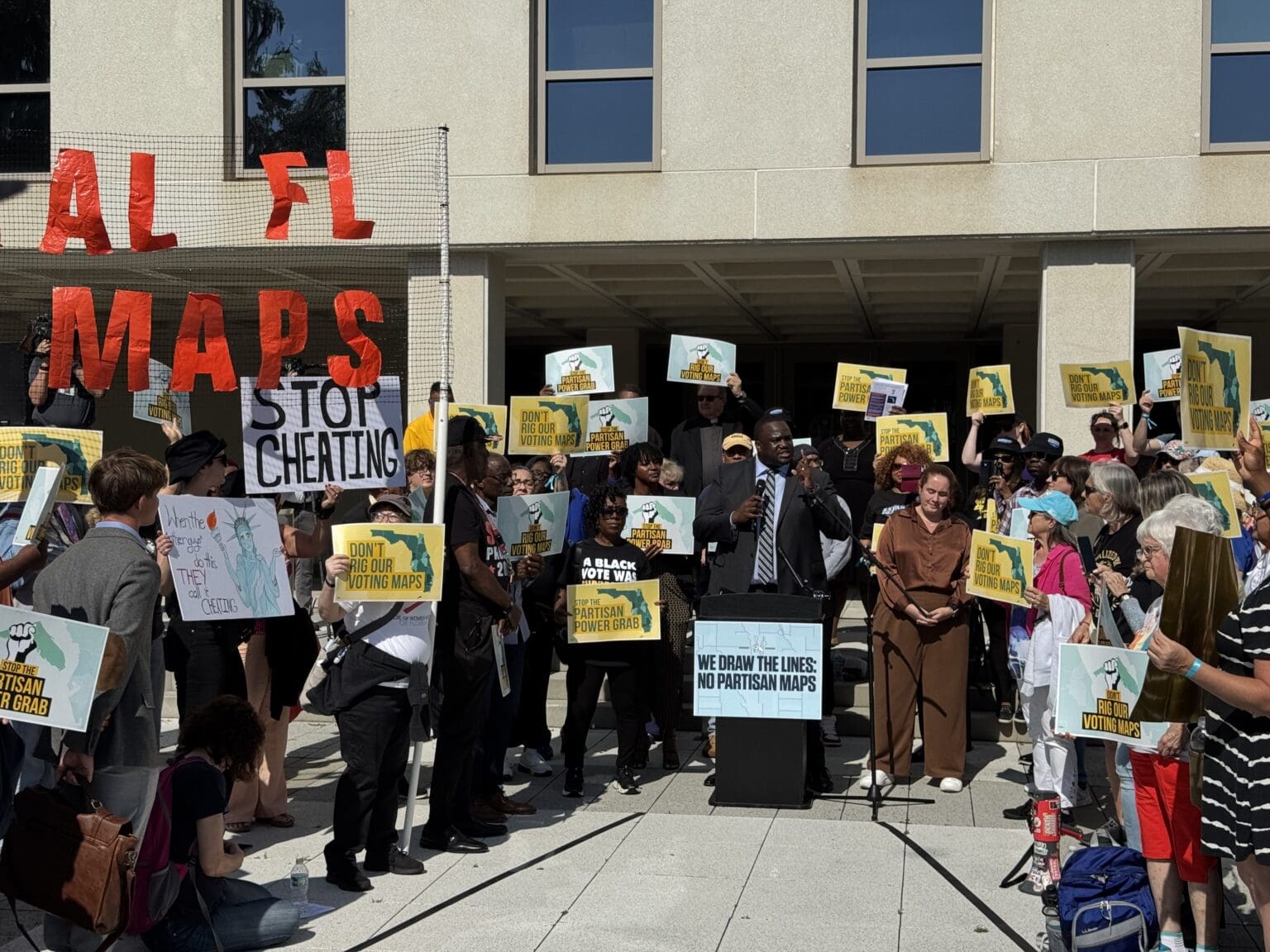 Citizens protesting redistricting in Florida, holding signs in front of the Florida capitol
