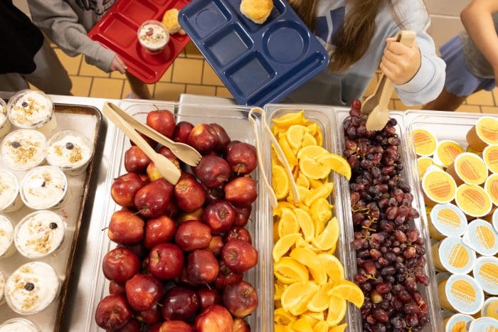 Fresh fruit and other breakfast food on a serving line in a school cafeteria
